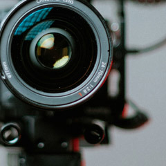Photo: Closeup of a video camera lens. Photo by Matteo Bernardis.