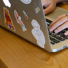 Photo: Closeup of stickers on a laptop computer. Photo by Mindspace Studio.
